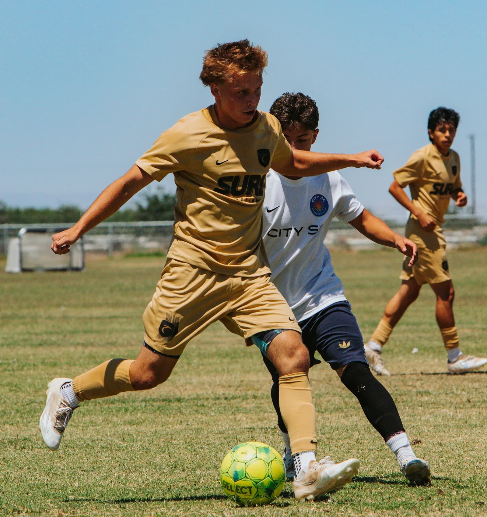 South Valley Surf boys player shielding the ball from a defender in a match