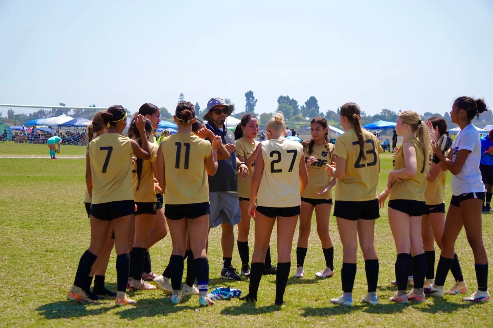 South Valley Surf girls huddled with their coach between tournament matches